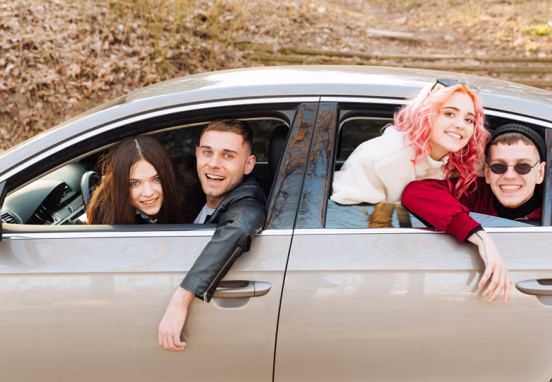 Groupe de personnes souriantes dans une voiture